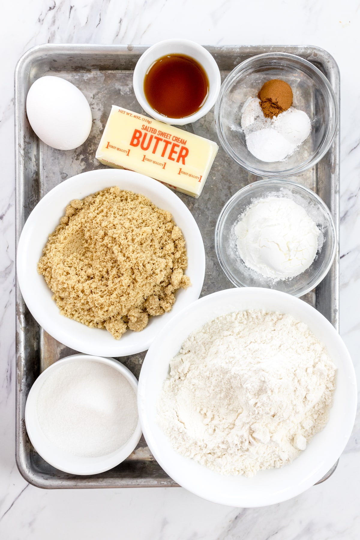 Top view of ingredients needed to make Churro Cookies in small bowls on a baking tray.