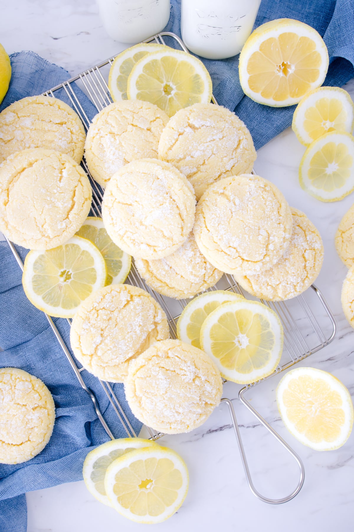 Top view of lemon sugar cookies in a pile mixed with lemon slices.