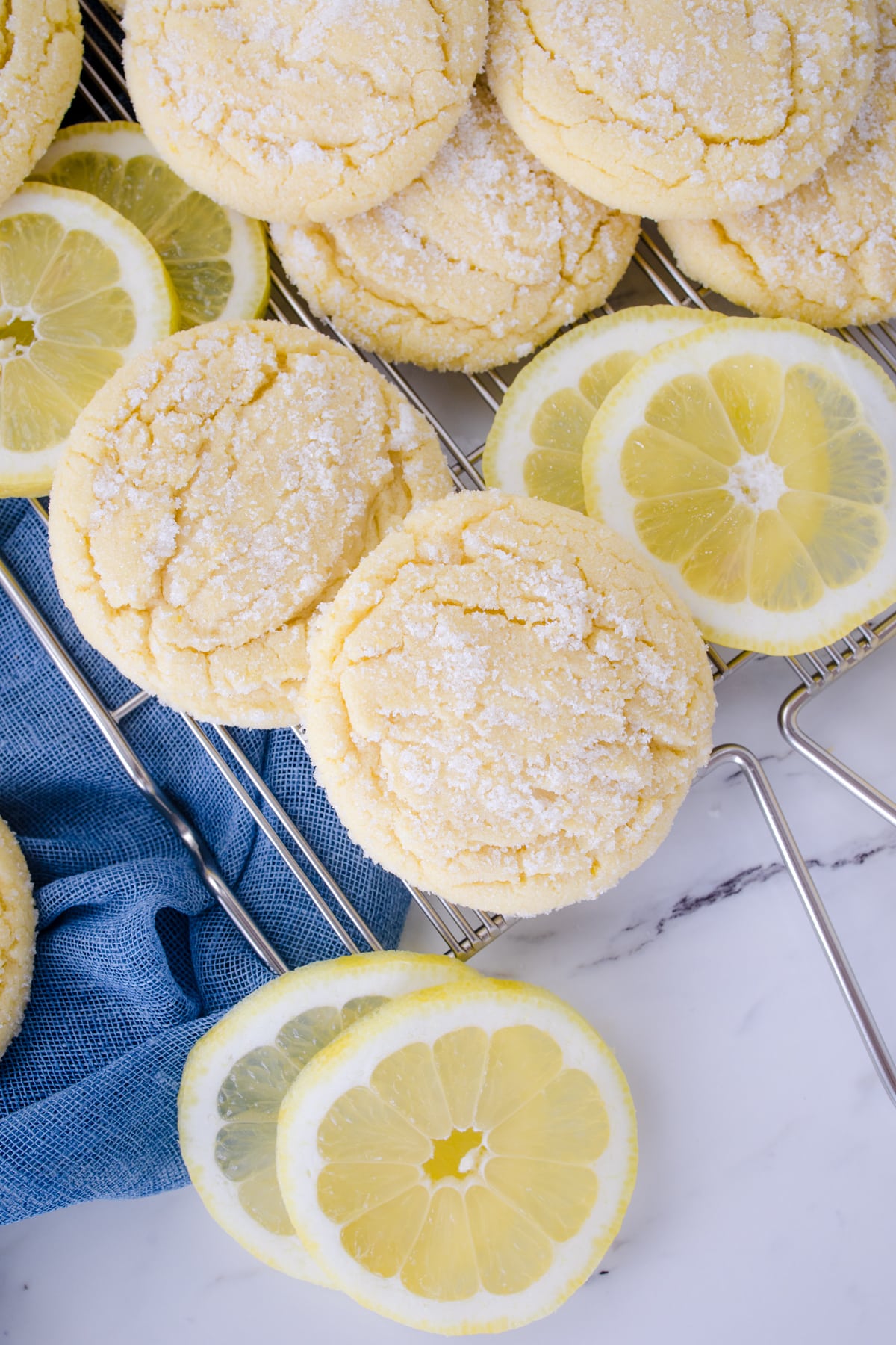 Top view of lemon sugar cookies in a pile mixed with lemon slices.