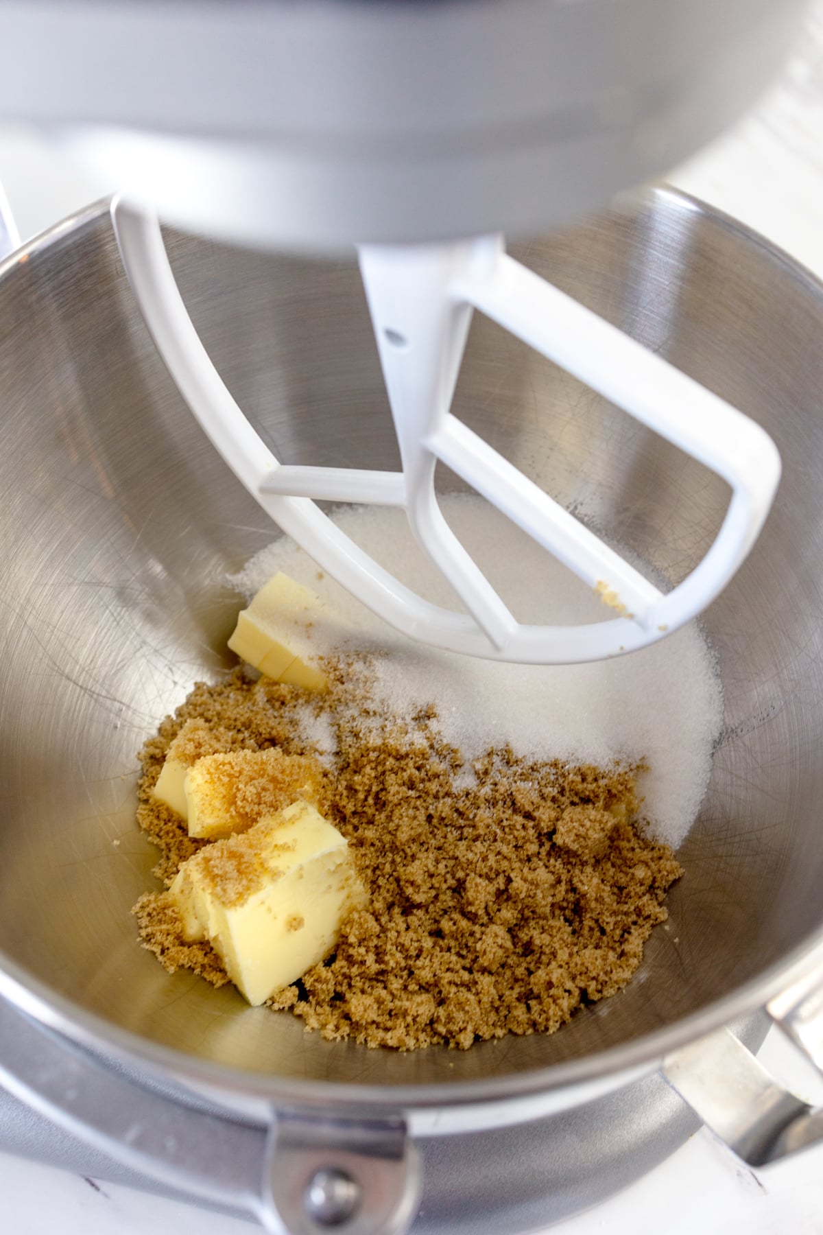 Close up of the bowl of a stand mixer with butter and sugars in it.