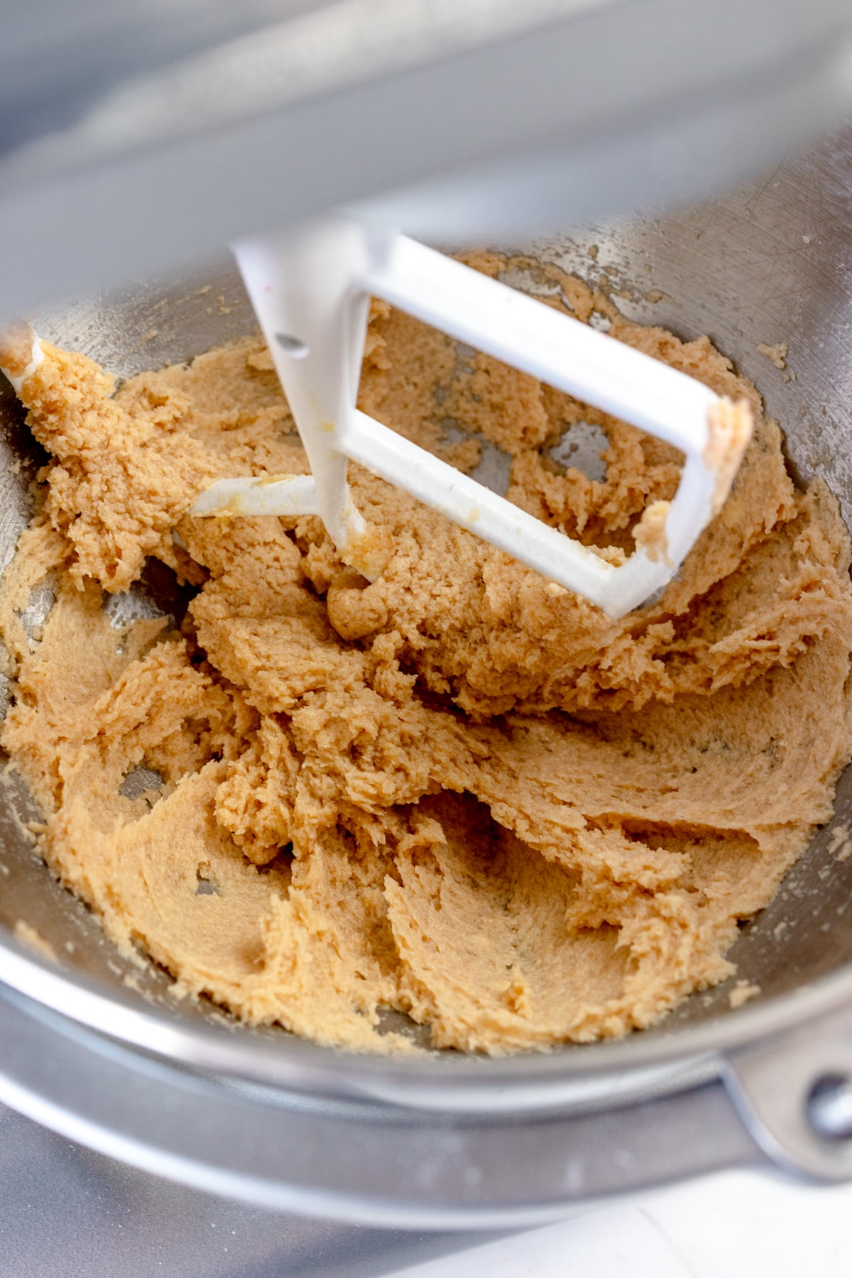 Close up of the bowl of a stand mixer with a creamed mixture in it.