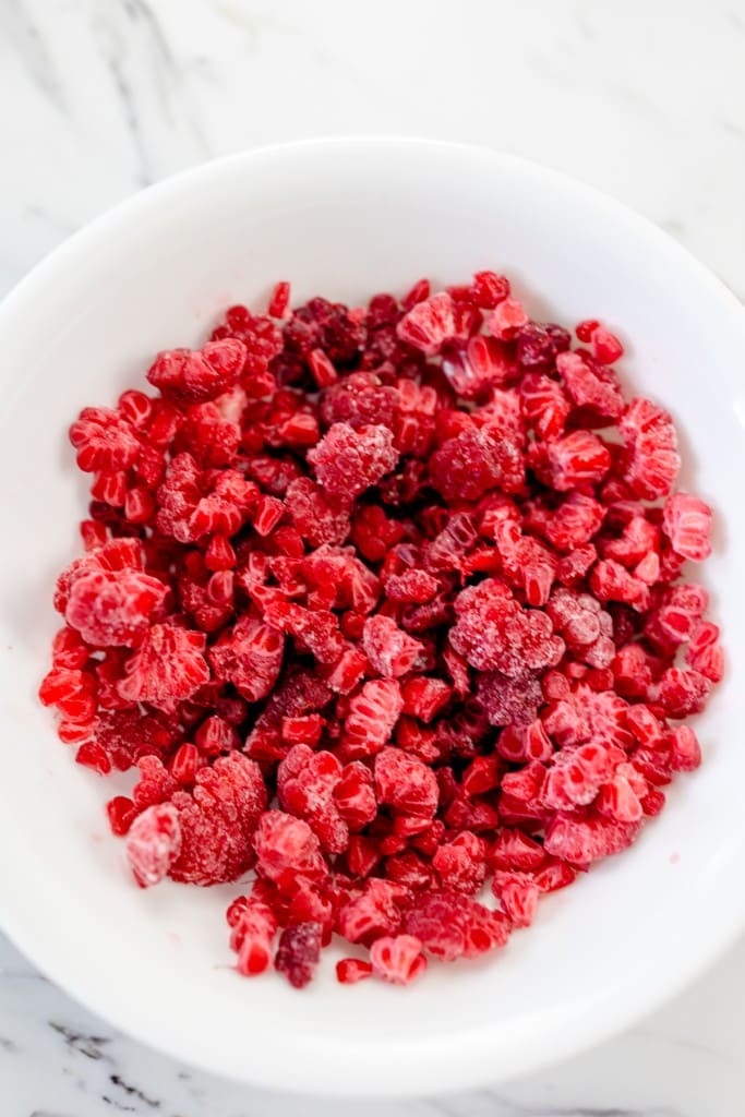 Frozen Raspberries broken in tiny bits in bowl