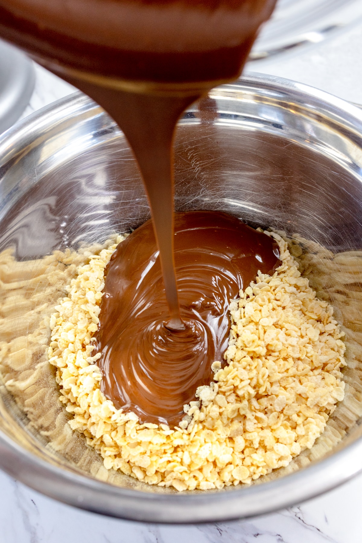 Pour melted chocolate mixture over rice krispie cereal