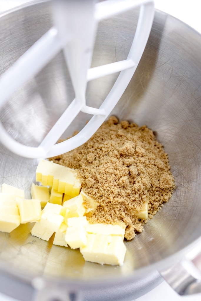 Close up of bworn sugar and butter in the bowl of a stand mixer with a paddle attachment.