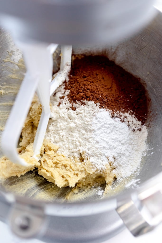Close up of a creamed mixture with flour and cocoa powder in it.