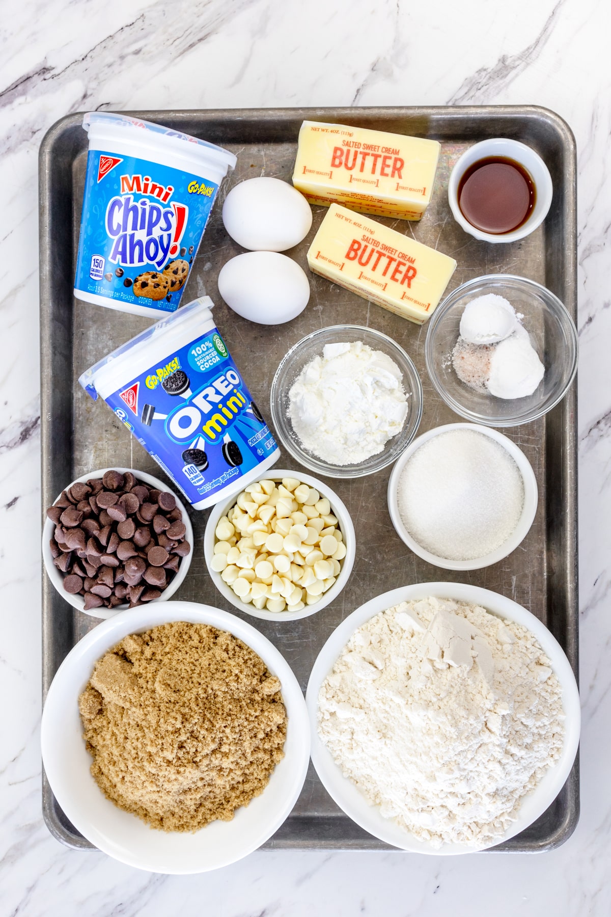 Top view of ingredients needed to make Cookie Monster Cookies in small bowls on a baking tray.