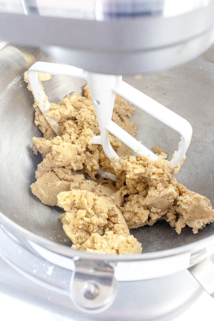 Close up of the bowl of a stand mixer with a butter and sugar mixture in it.