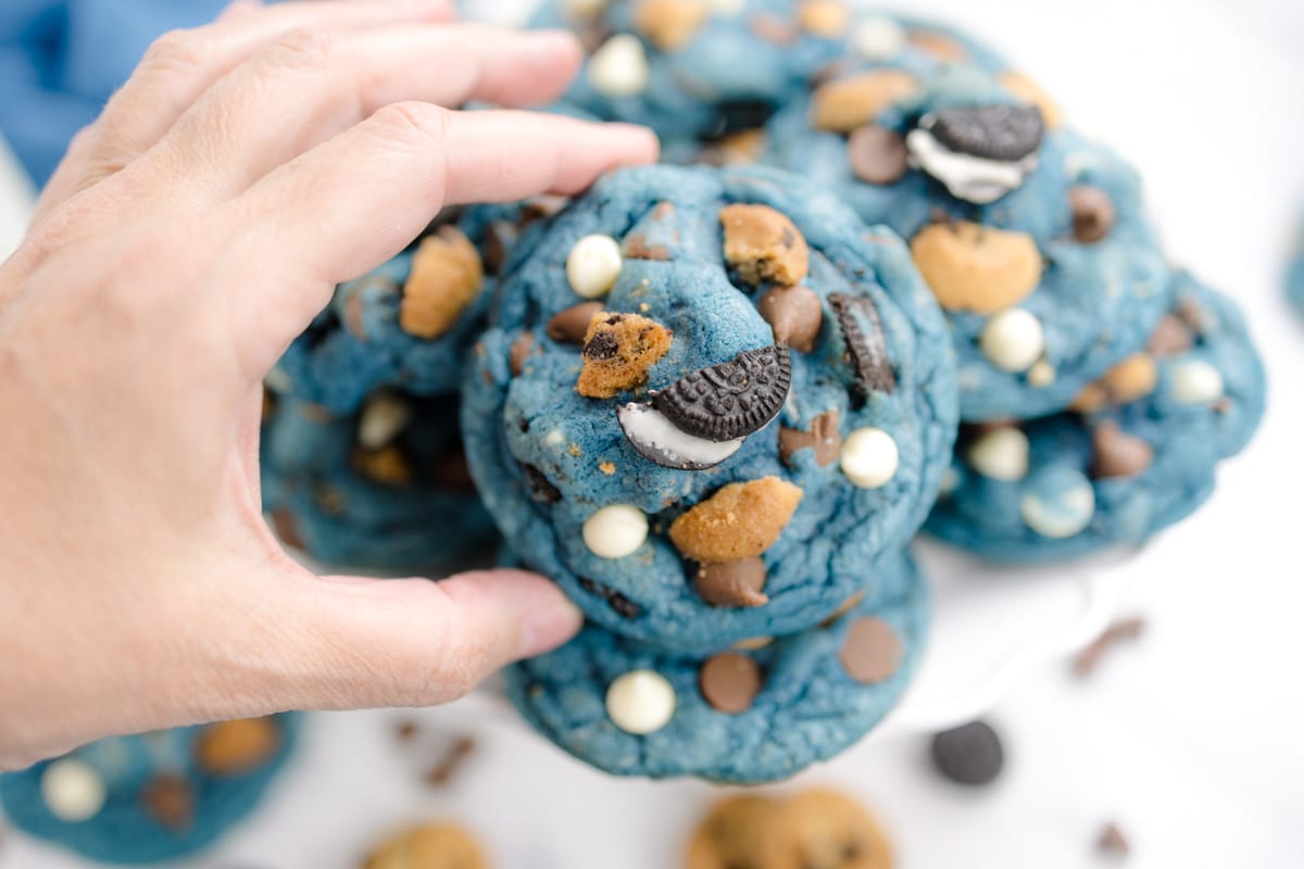 Top view of a Cookie Monster Cookie being picked up by a hand.
