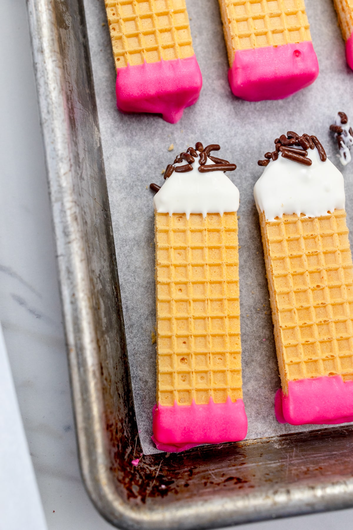 Pencil Wafer Cookies on a parchment paper lined baking sheet.