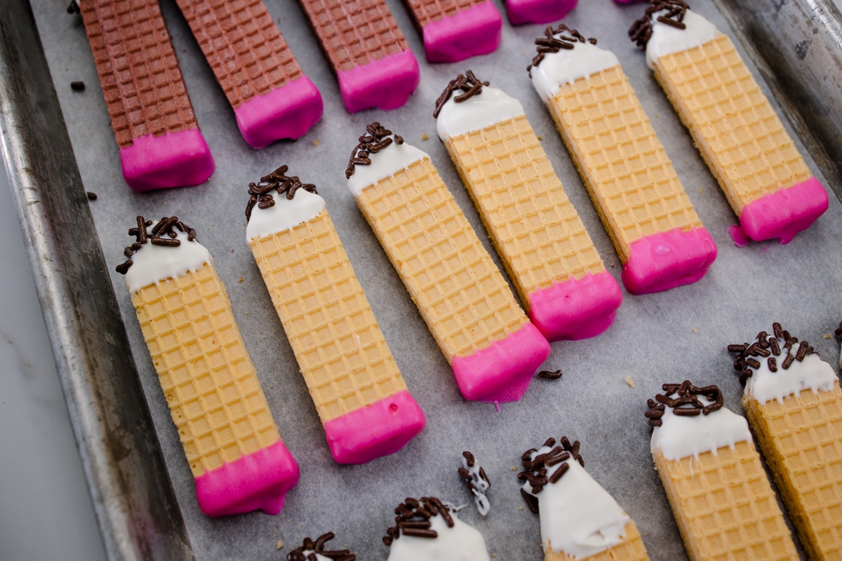 Pencil Wafer Cookies on a parchment paper lined baking sheet.