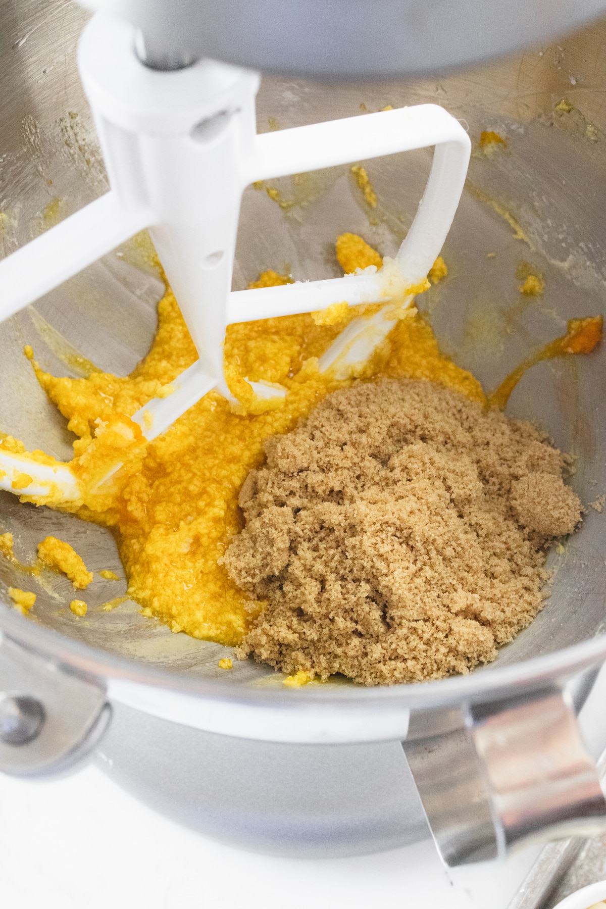 Close up of the bowl of a stand mixer with brown sugar and cookie mixture in the bowl.