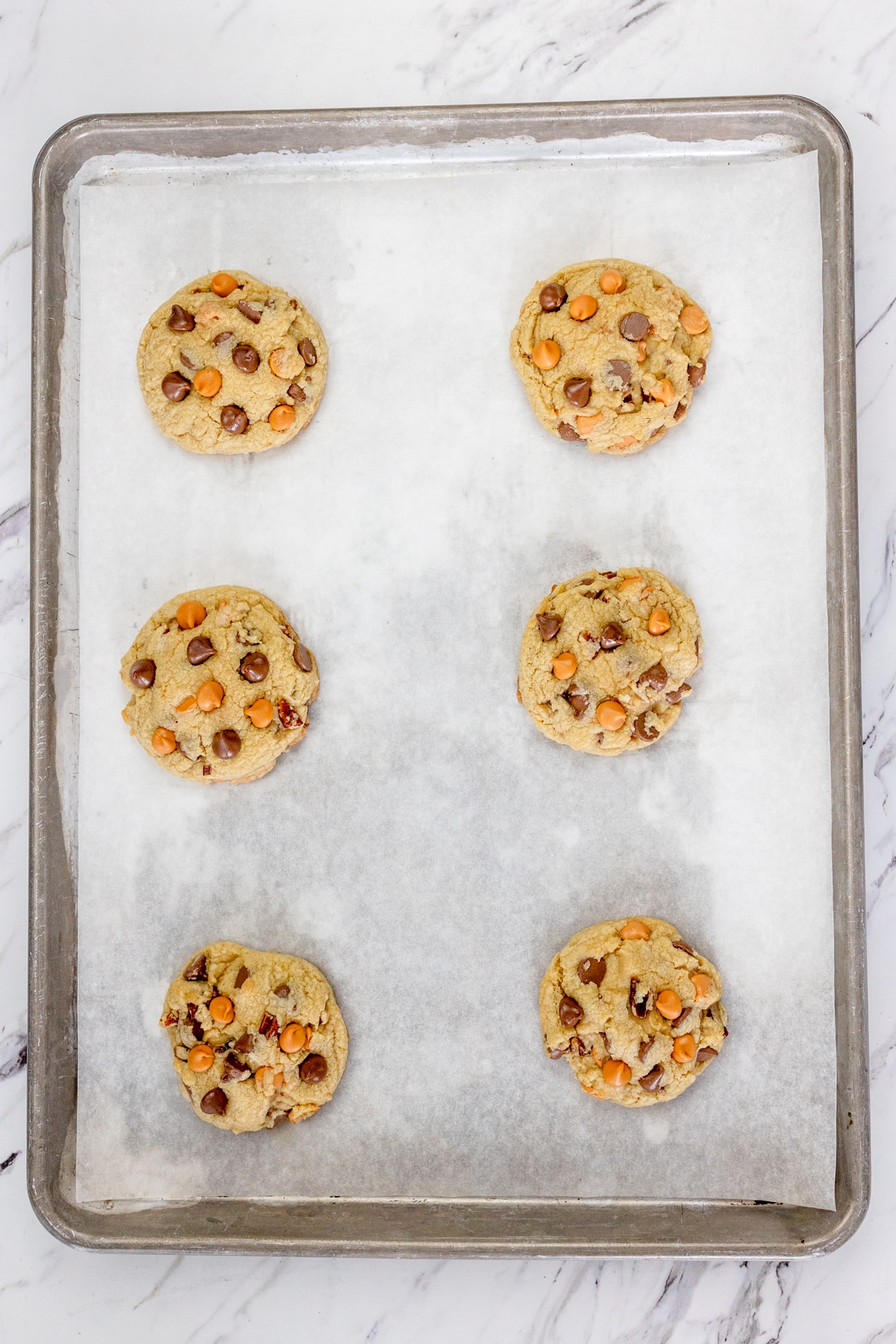 Top view of Butterscotch Chocolate Chip Cookies on a baking tray lined with parchment paper.