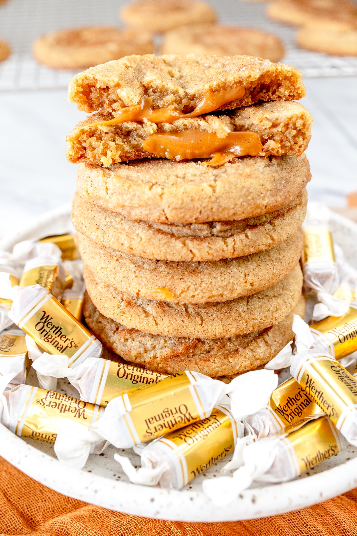 Close up of a Caramel Snickerdoodle Cookie broken in half on top of a stack of Caramel Snickerdoodle Cookies.