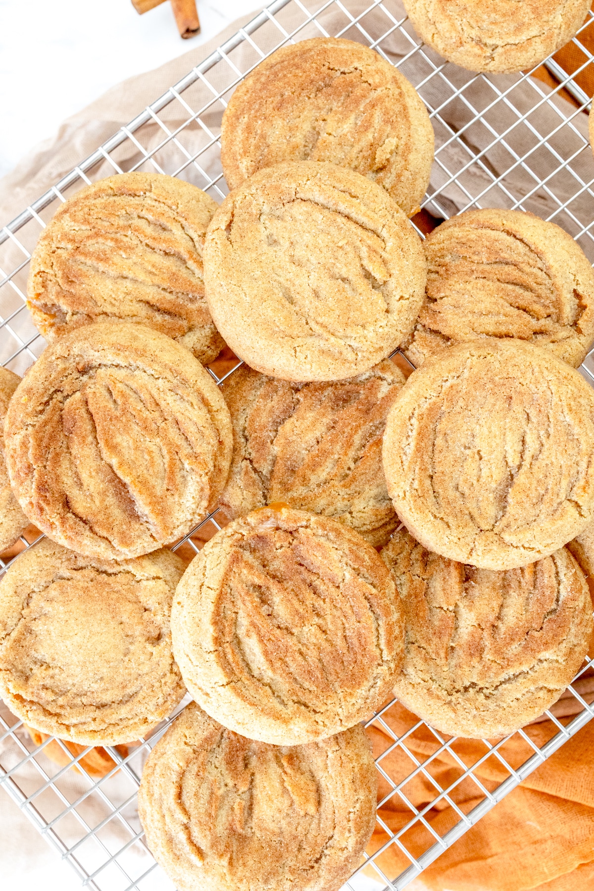 Top view of a pile of Caramel Snickerdoodle Cookies on a wire rack.
