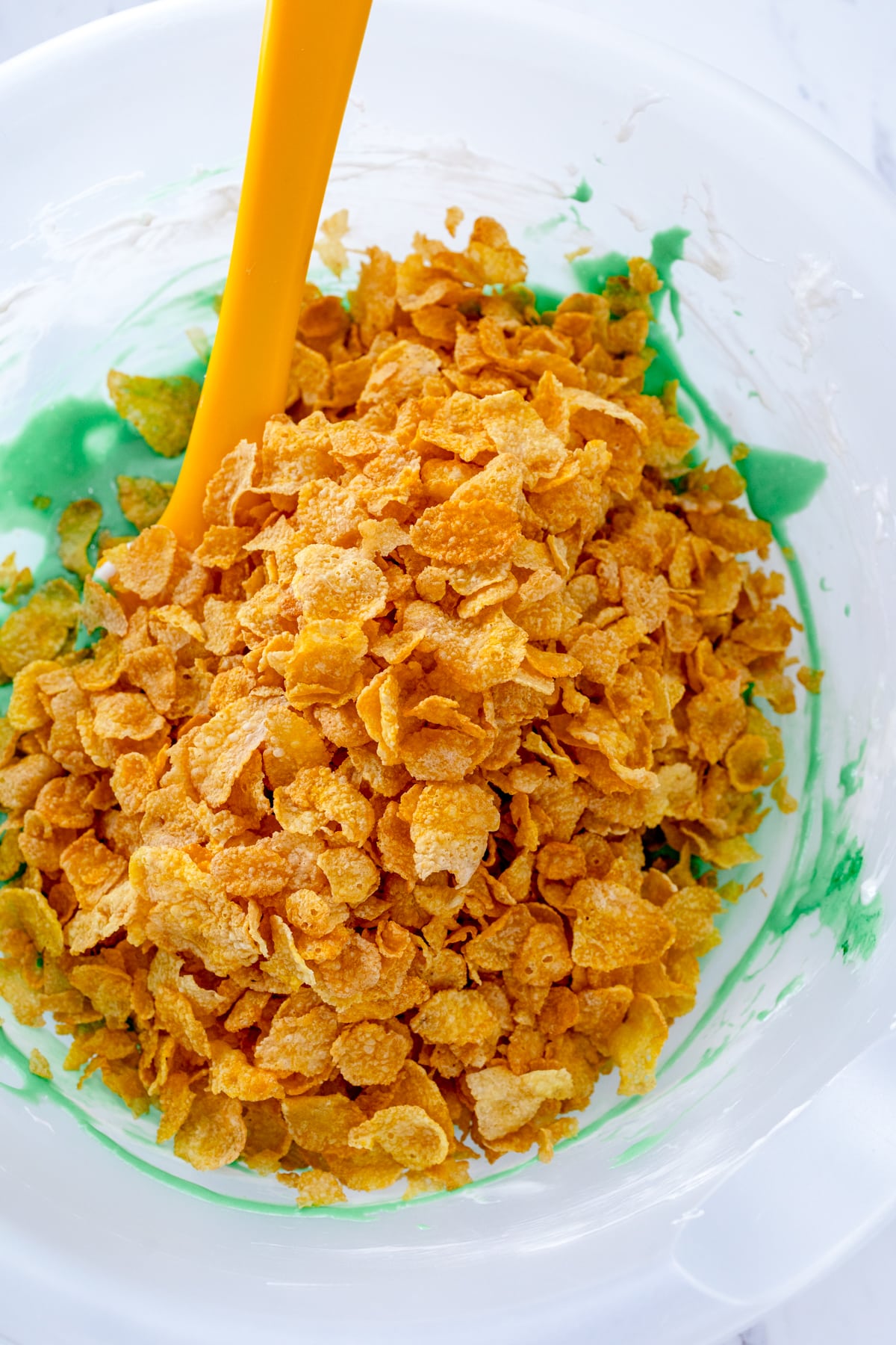 Close up of cornflakes being added to the mixture.