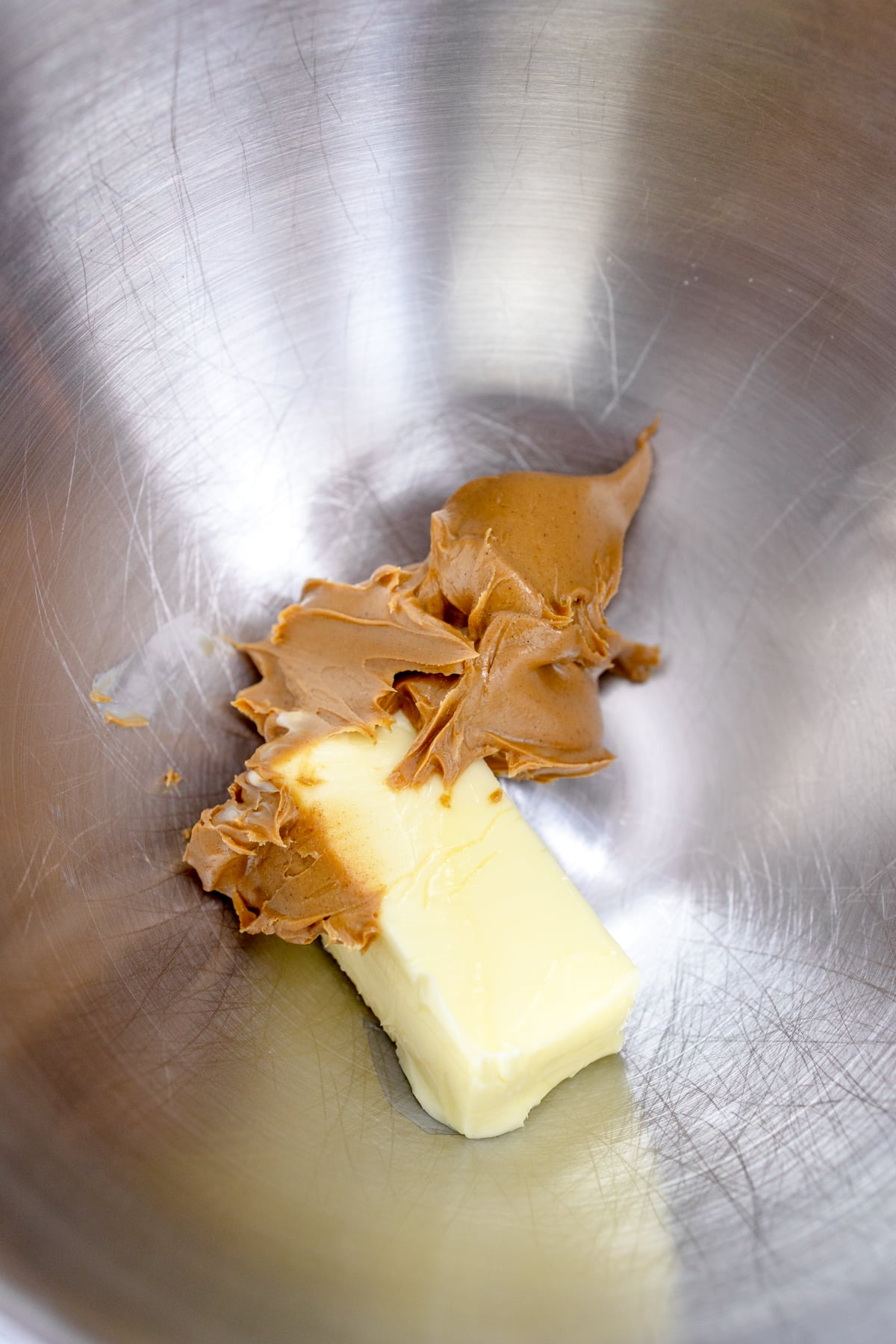 Close up of the bowl of a stand mixer with butter and peanut butter in it.