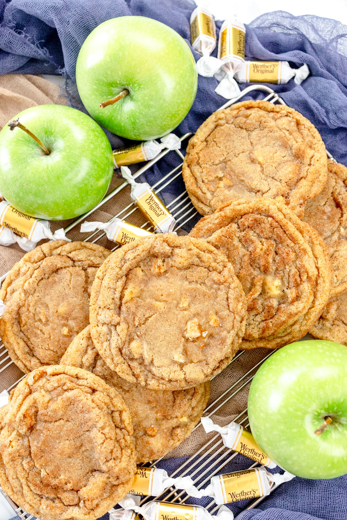 Top view of caramel apple snickerdoodle cookies surrounded by apples and Werther's Original caramels.