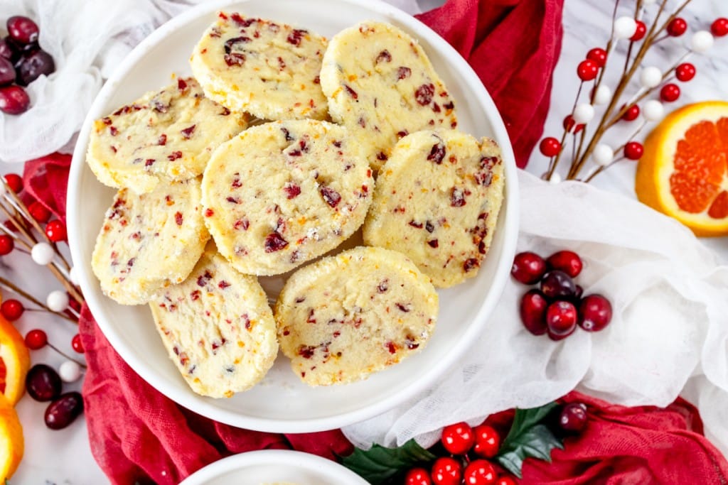Top view of Cranberry Orange Shortbread Cookies in a stack on a plate.