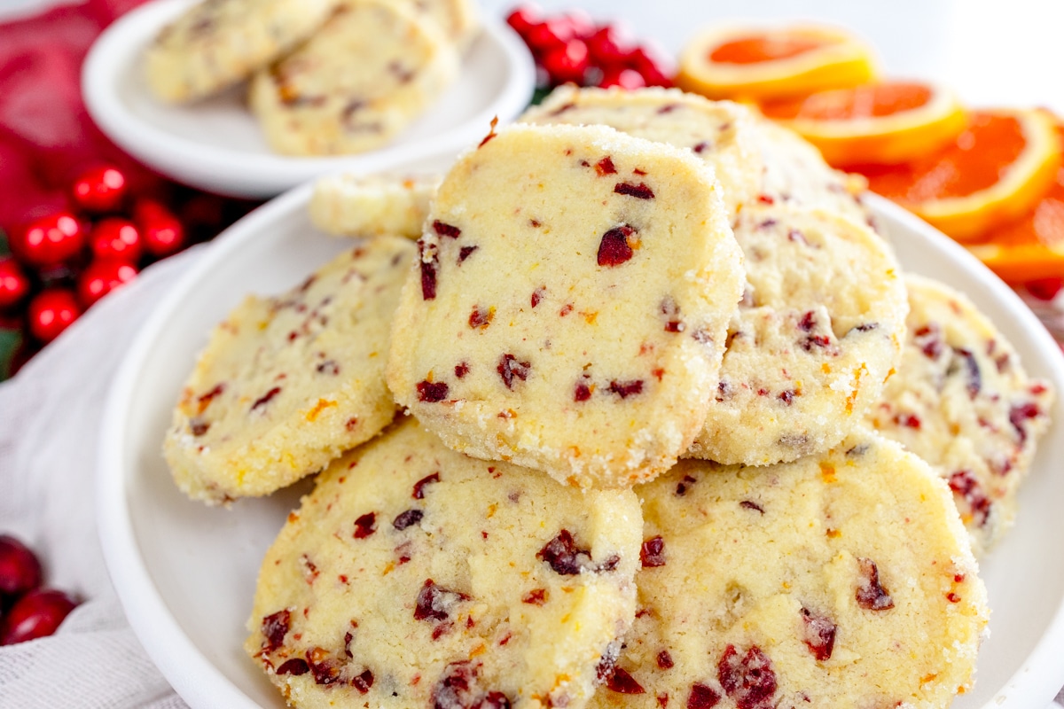 Close up of Cranberry Orange Shortbread Cookies in a stack on a plate.