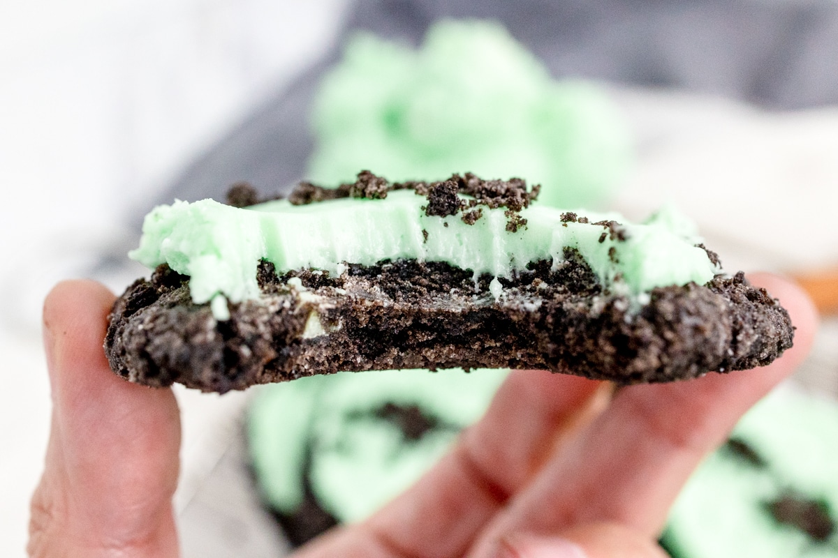 Close up view of Frosted Mint Oreo Cookie with a bite taken out of it to reveal the middle.