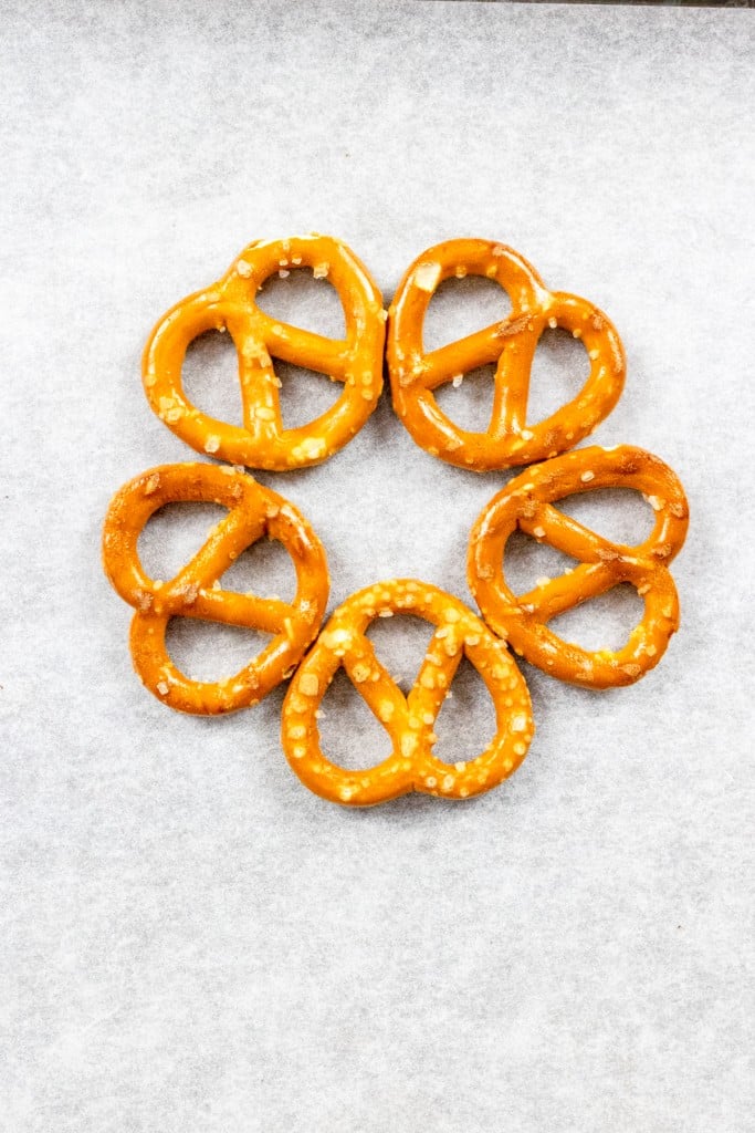 5 Mini Twist Prezels on parchment paper in a circle to form a wreath
