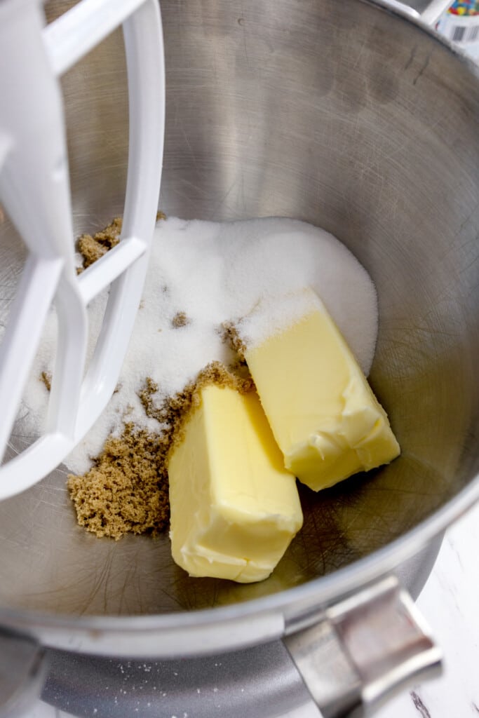 Close up of the bowl of a stand mixerwith butter and sugars in it.