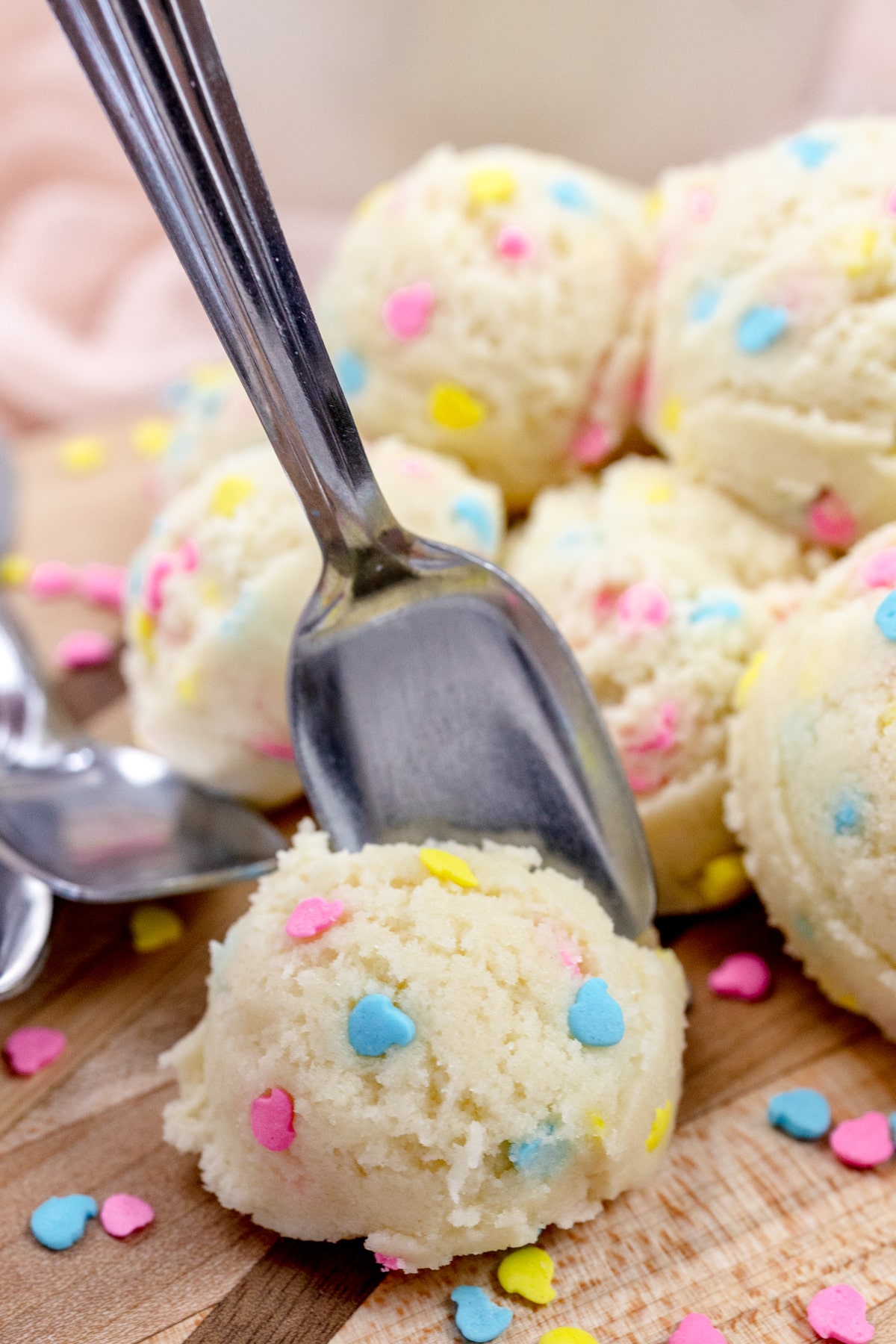 Close up view of scoops of edible sugar cookie dough with an ice cream spoon.