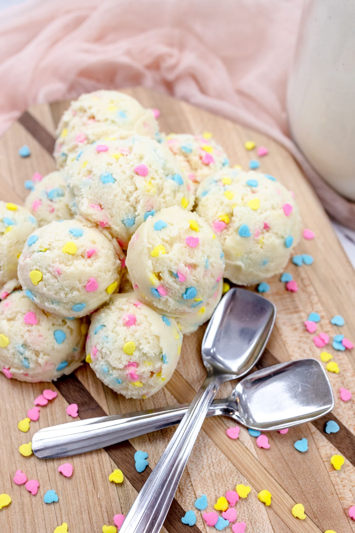Scoops of edible sugar cookie dough with ice cream spoons.
