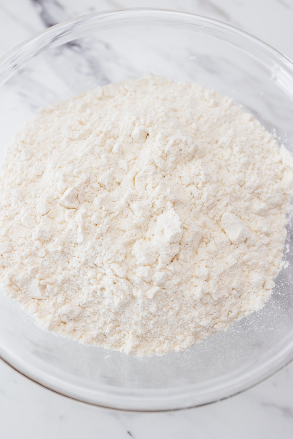 Close up view of flour in a microwavable bowl.