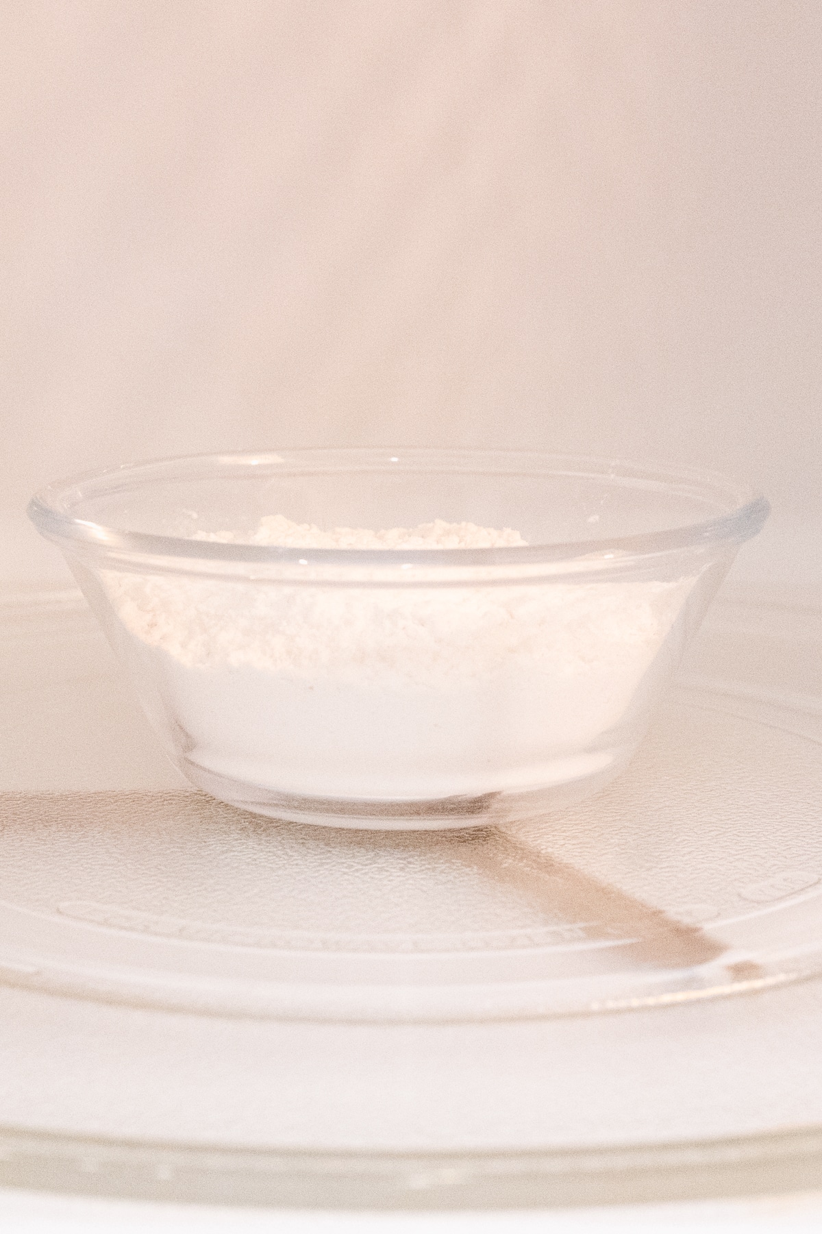 Close up view of flour in a microwavable bowl in the microwave.