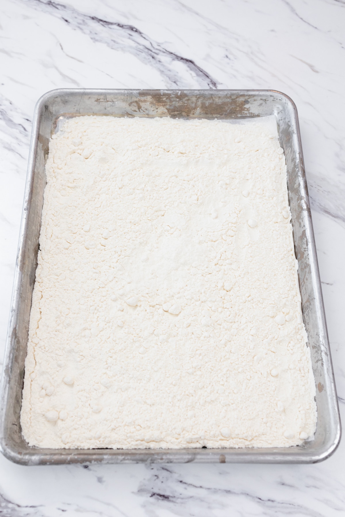 Top view of flour cooling on a parchment-lined baking sheet.