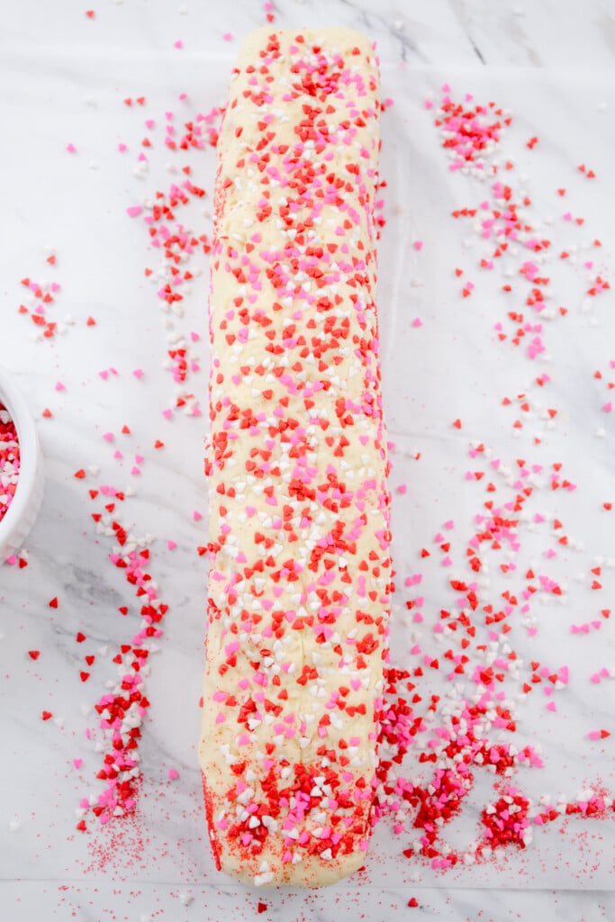 Top view of the cookie dough log which has been rolled in sprinkles.
