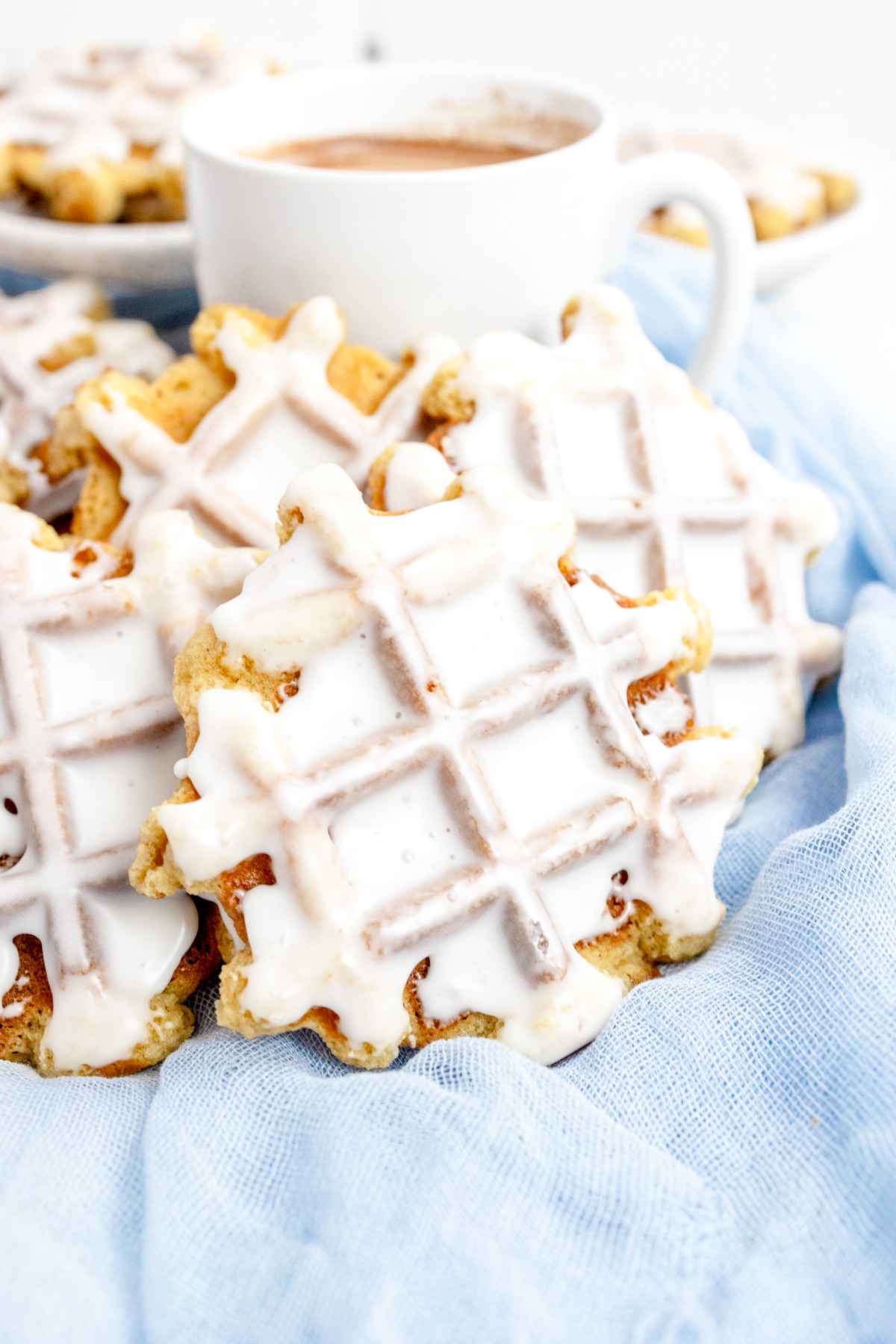 Close up of waffle cookies leaning against a white mug.