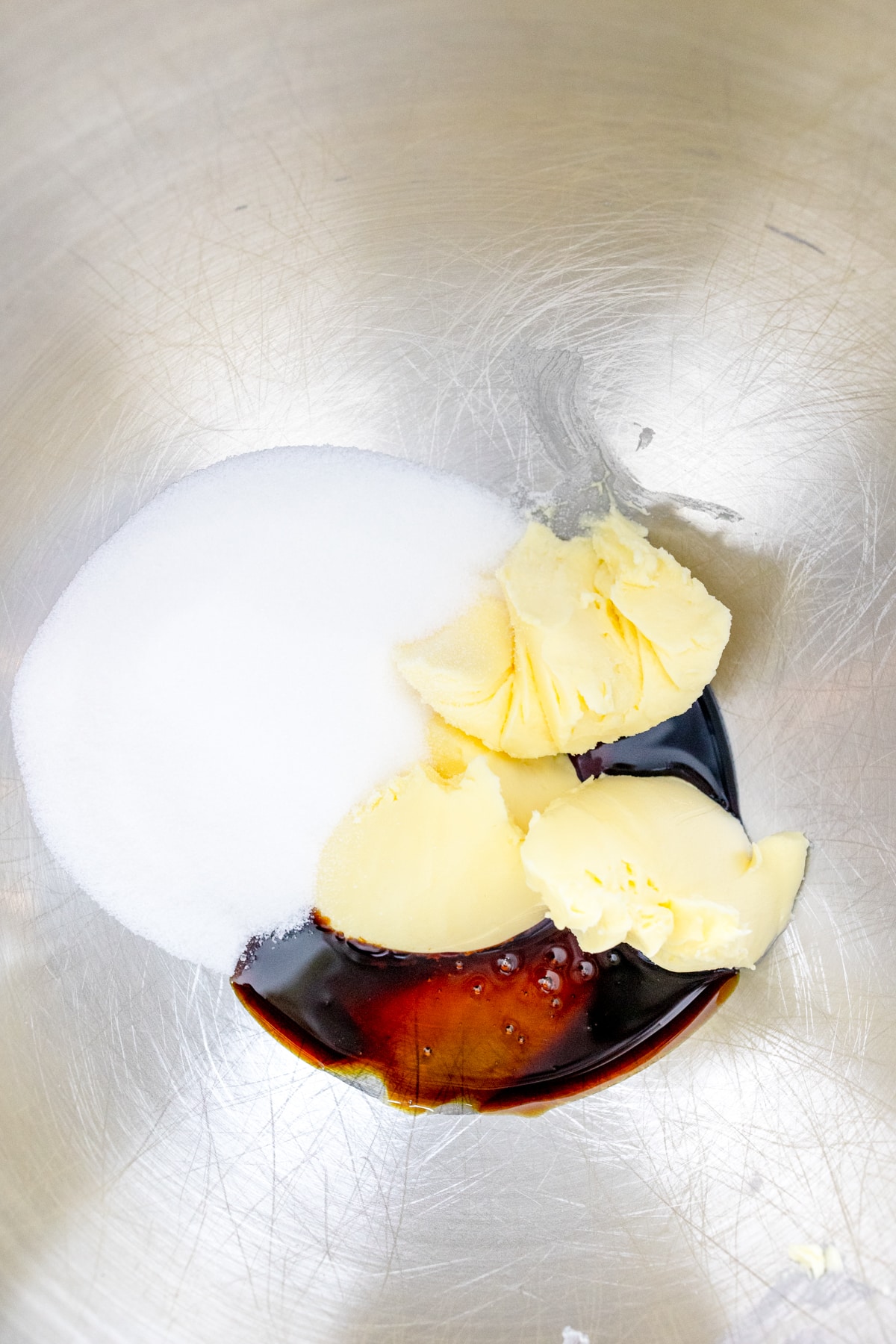 Close up of the bowl of a stand mixer with crisco, sugar, and molasses ready to be creamed together.