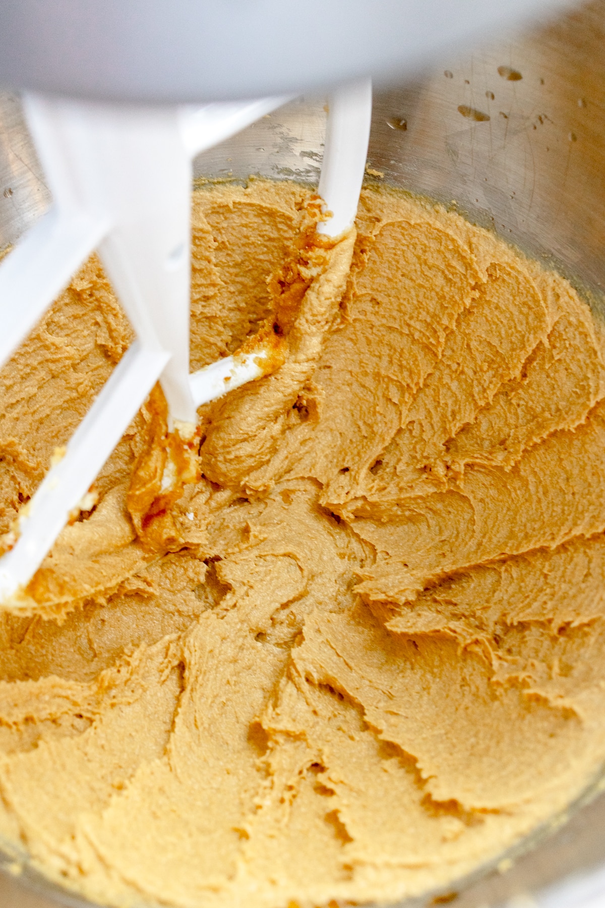 Close up of the bowl of a stand mixer with a creamed mixture.