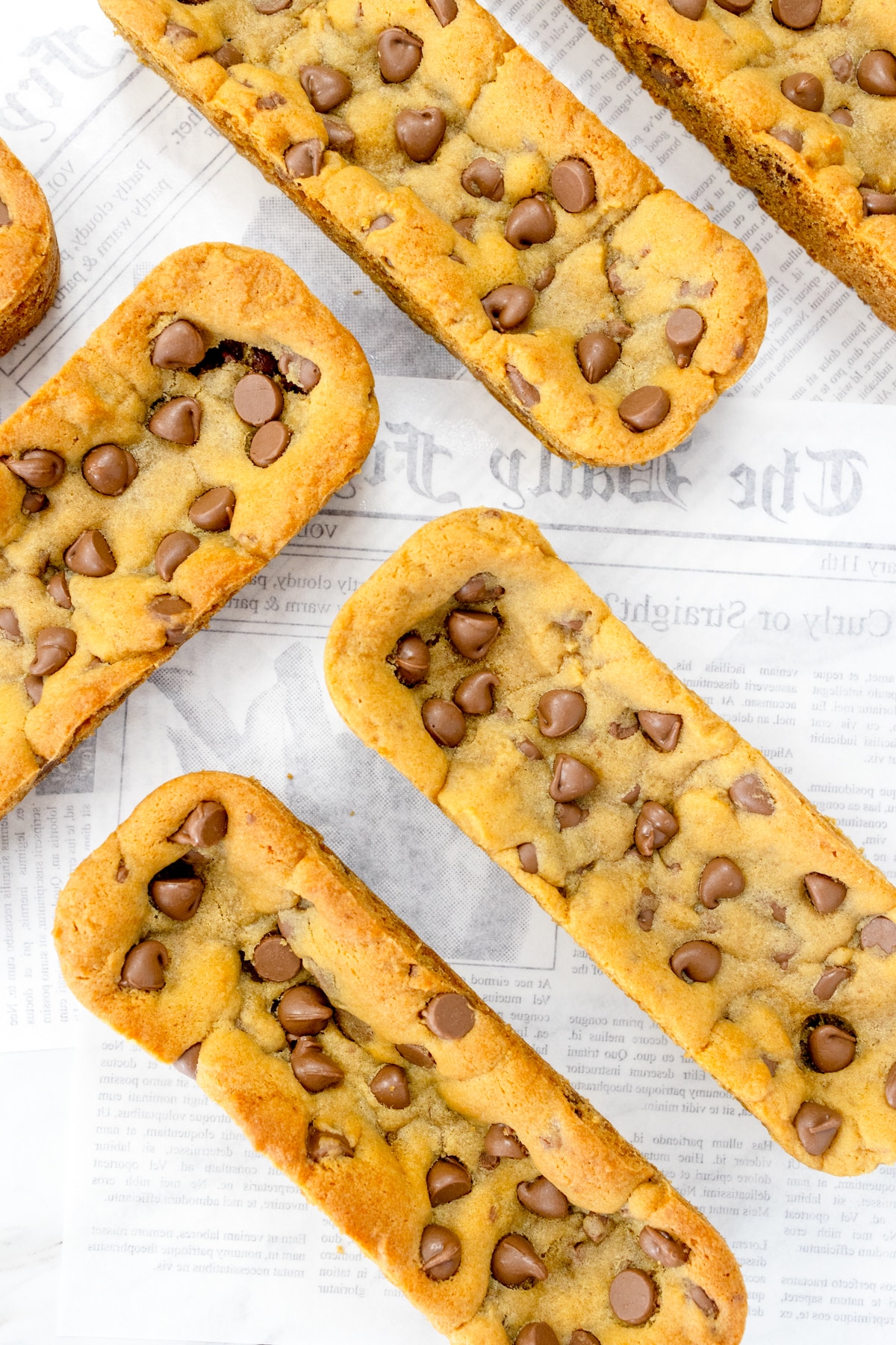 Close up of Subway Footlong Cookies on a white faded newspaper surface.