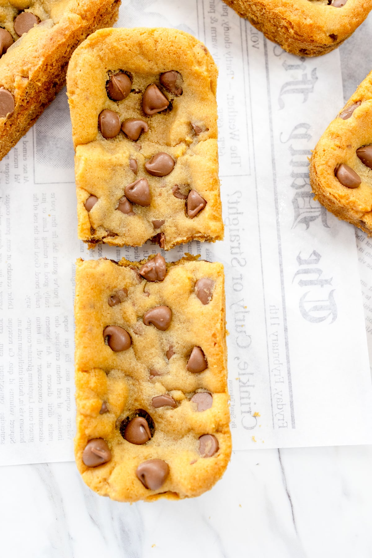 Close up of Subway Footlong Cookies on a white faded newspaper surface.