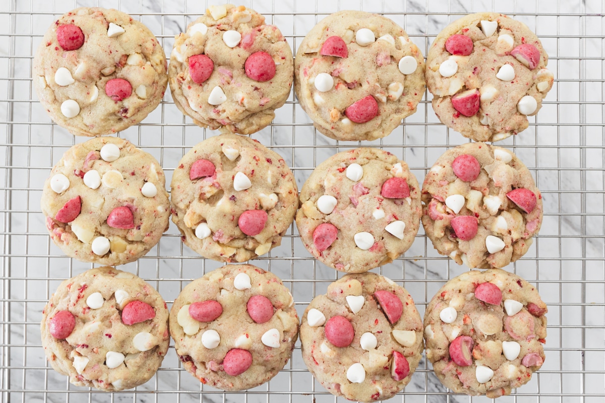 Top view of Strawberry White Chocolate Macadamia Nut Cookies on a wire rack.