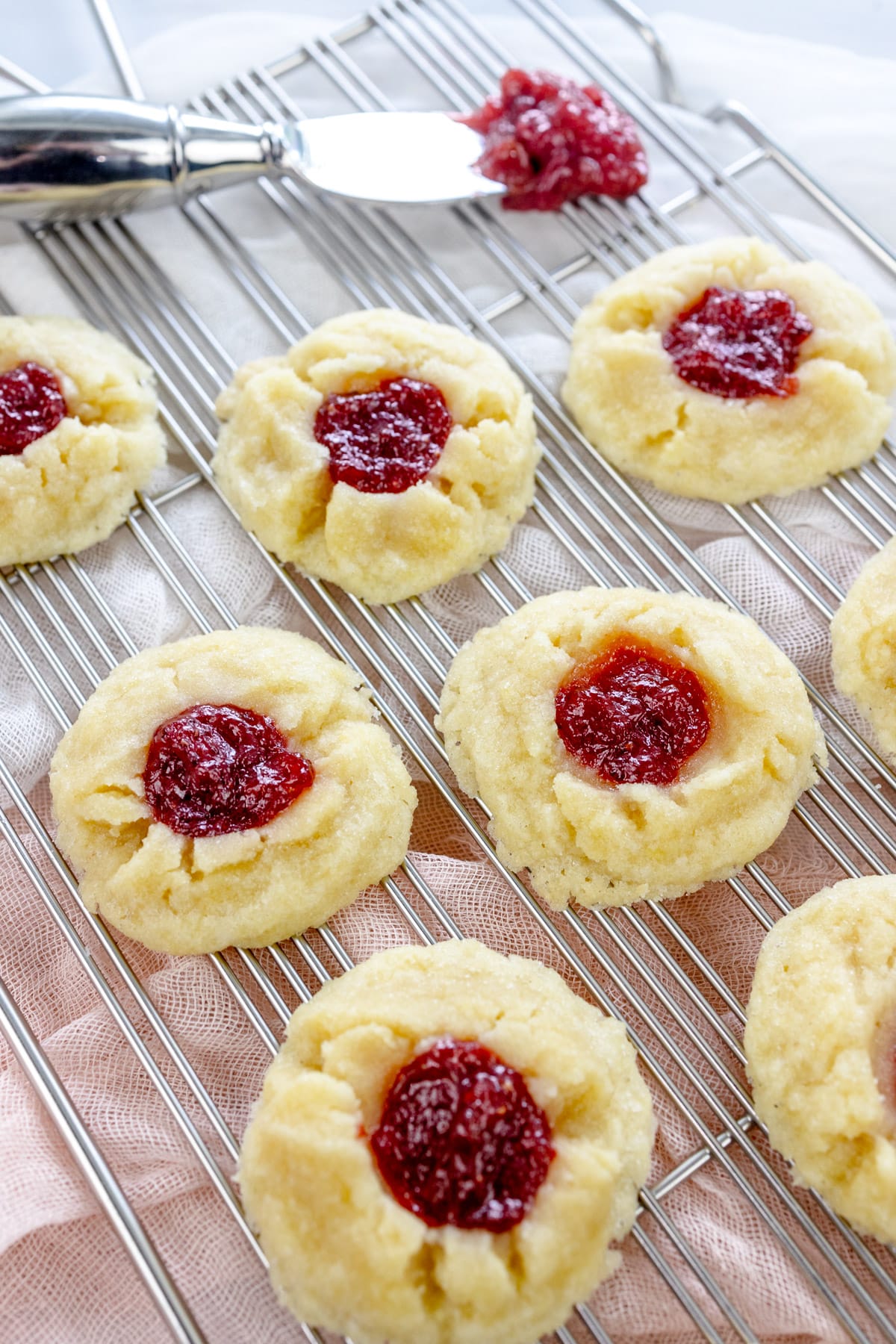 Close up image of Fig Jam Cookies on a wire rack next to a knife with jam on it.