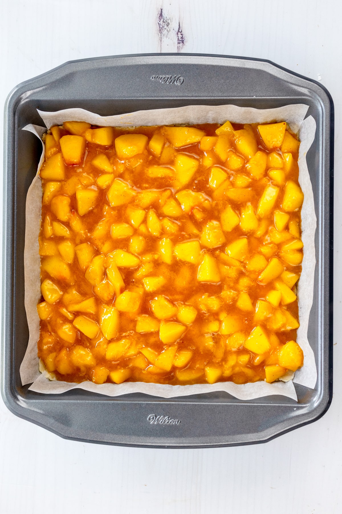 Overhead image of the peach filling for Peach Pie Bars added to the dish.