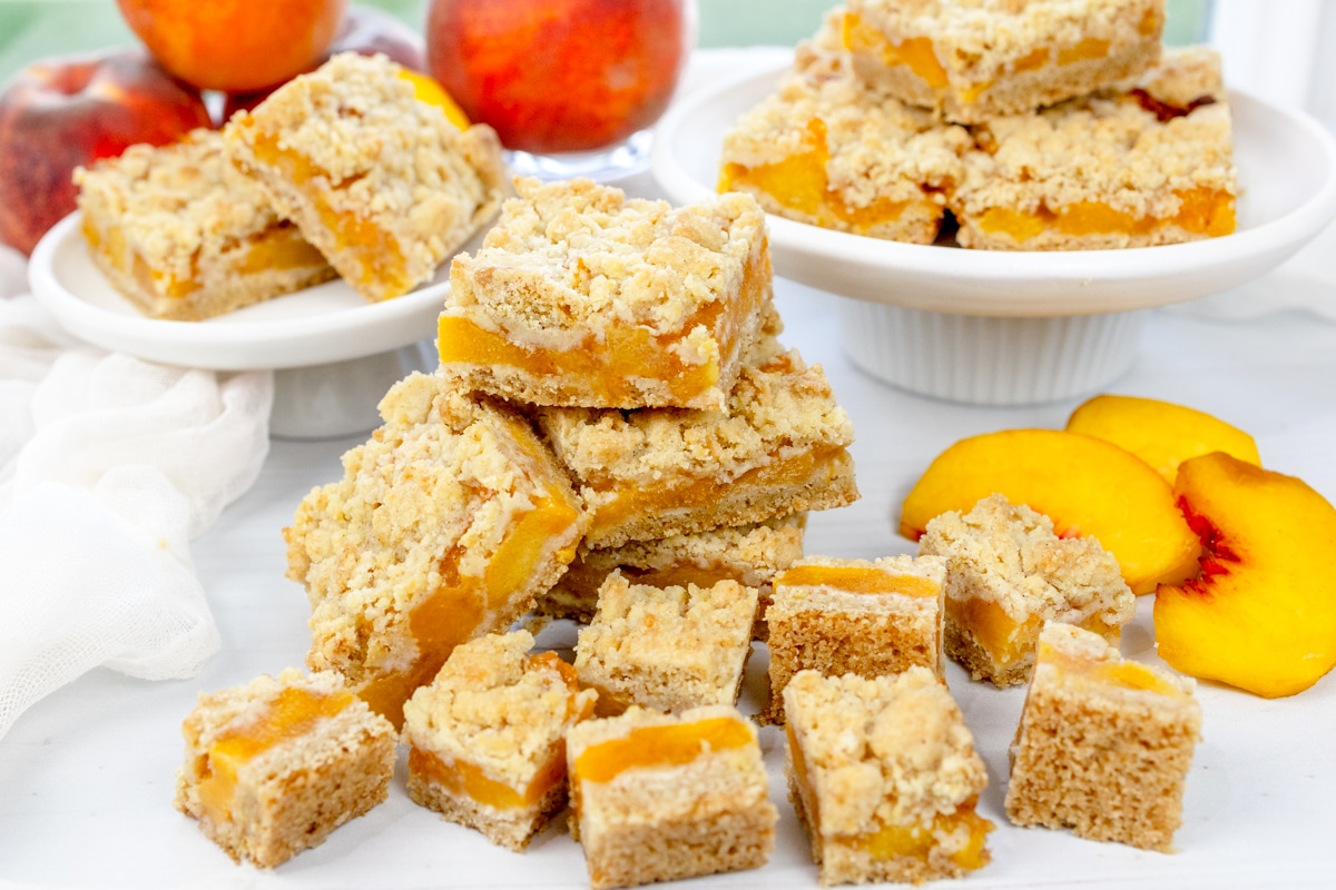 Angled image of Peach Pie Bars in a pile and on plates.