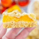 Close up image of a hand holding a Peach Pie Bar.