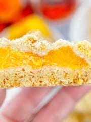 Close up image of a hand holding a Peach Pie Bar.