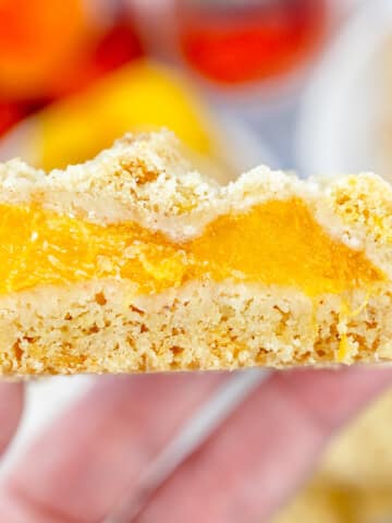 Close up image of a hand holding a Peach Pie Bar.