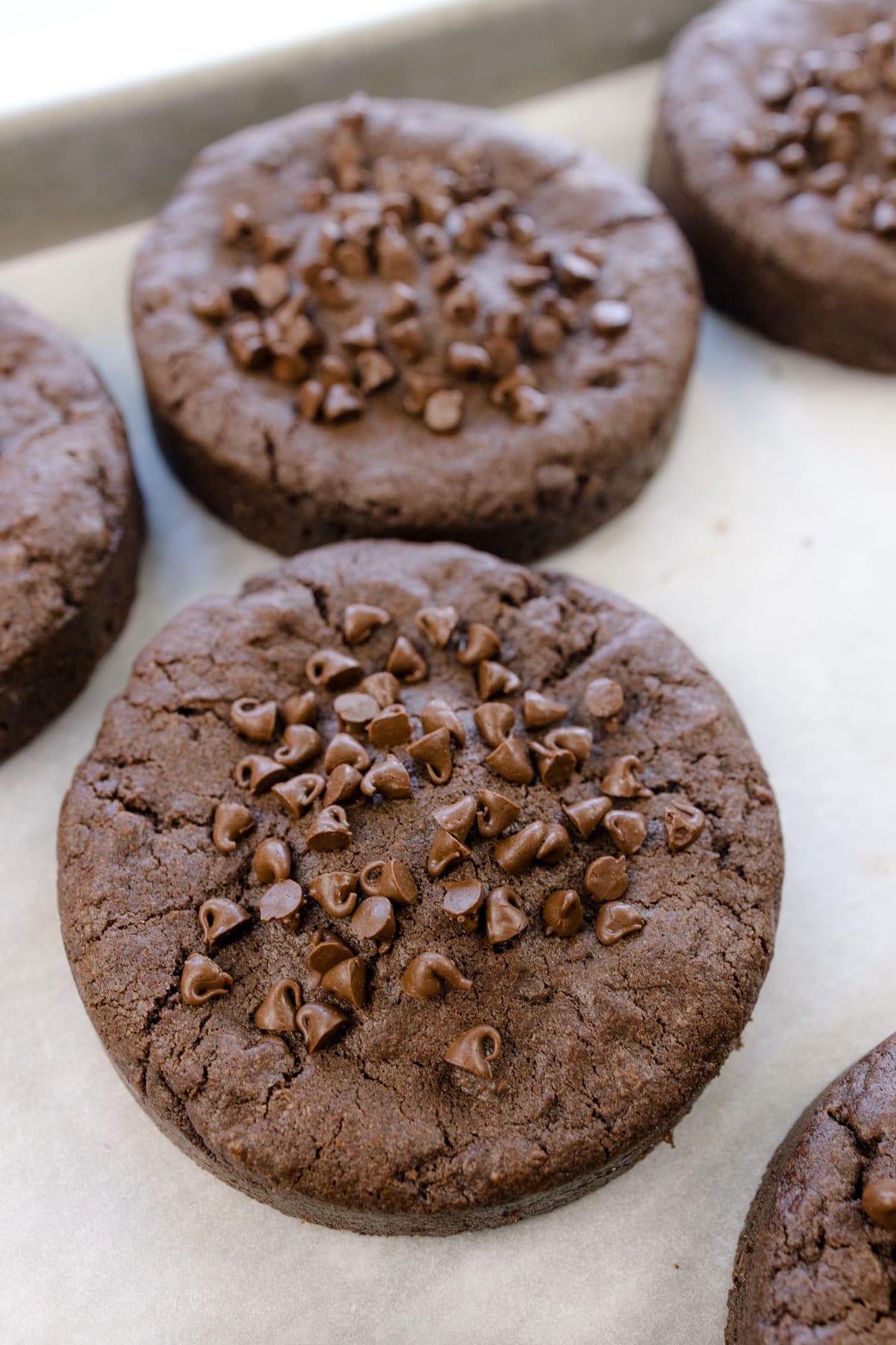 Close up shot of Peanut Butter Stuffed Chocolate Cookies on a baking tray lined with parchment paper.